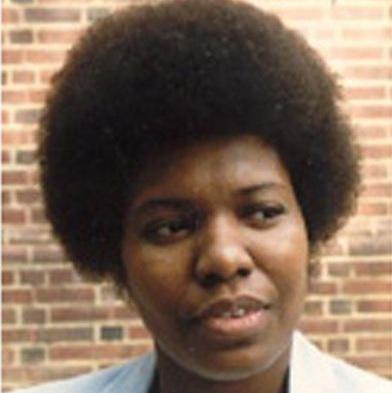 black woman with a medium-sized afro looks off to the side