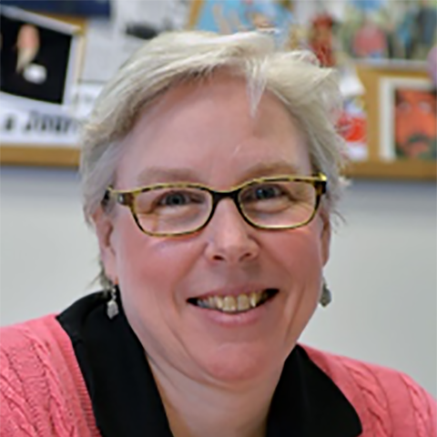 smiling white woman with glasses and short blond/gray/white hair